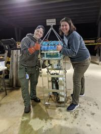 Two scientists giving a thumbs up in front of an autonomous eDNA sampler