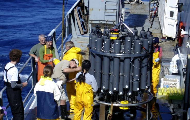 Scientists collecting samples from a CTD (Conductivity-Temperature-Depth) rosette. 