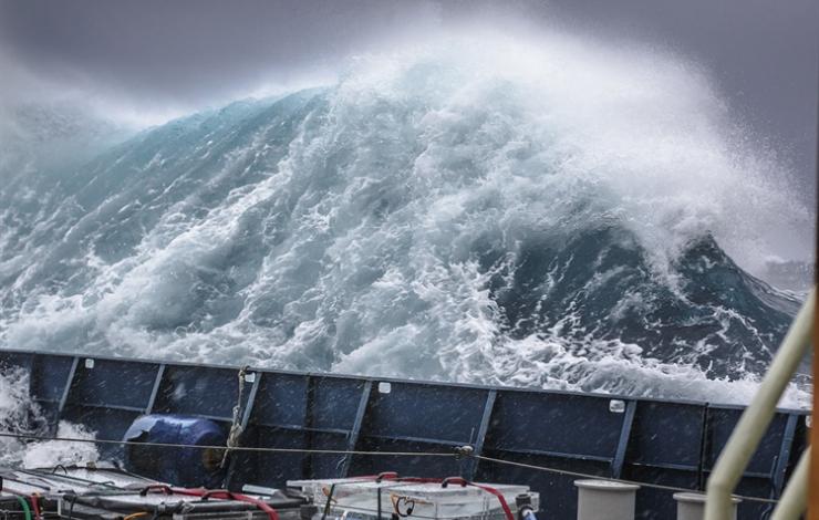 View of a storm from a research vessel. The wave height is significantly taller than the railing on the research vessel. 