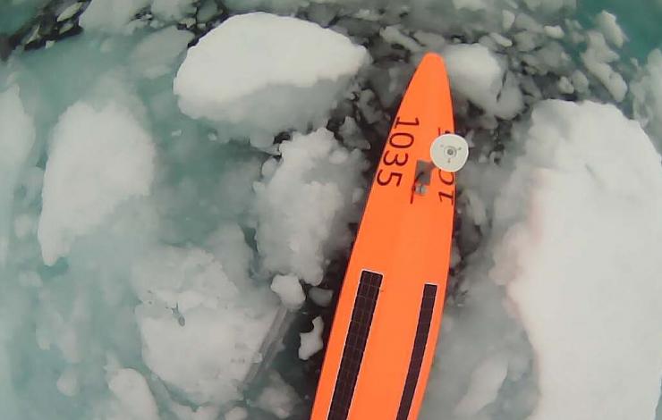 bright orange hull with solar panels surrounded by ice