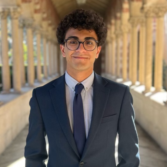 Ryan standing outdoors in corridor lined with white stone columns